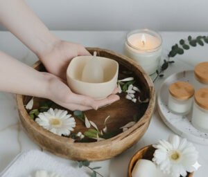 Image of washing moona stone period cup holder in a wooden bowl with flower petals and water.