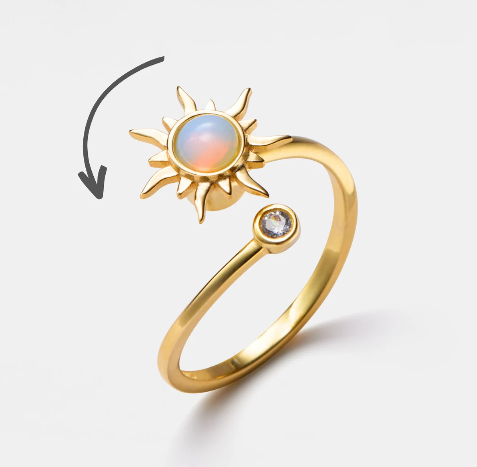 Quarter view Picture of Gold Sun Ring with spinning sun for anxiety and relaxation with arrow showing spin motion